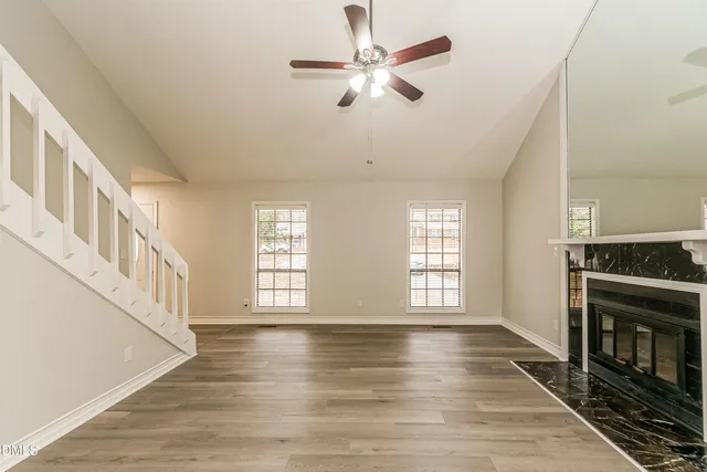 a view of an empty room with window and fireplace