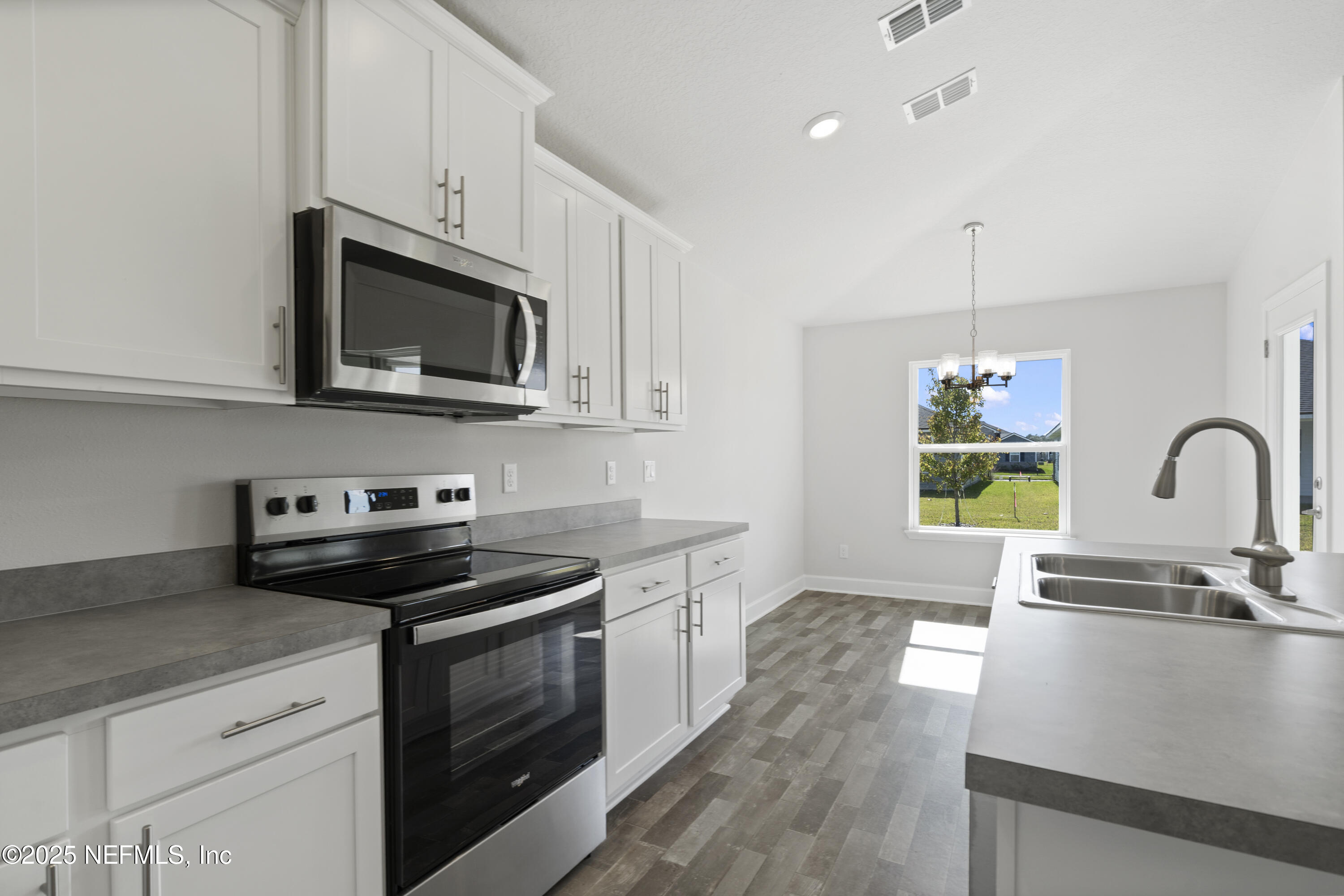 8346 Helmsley Boulevard Jacksonville, FL 32219 - Photo 5 of 24 a kitchen with stainless steel appliances granite countertop a sink a stove a microwave and wooden floors