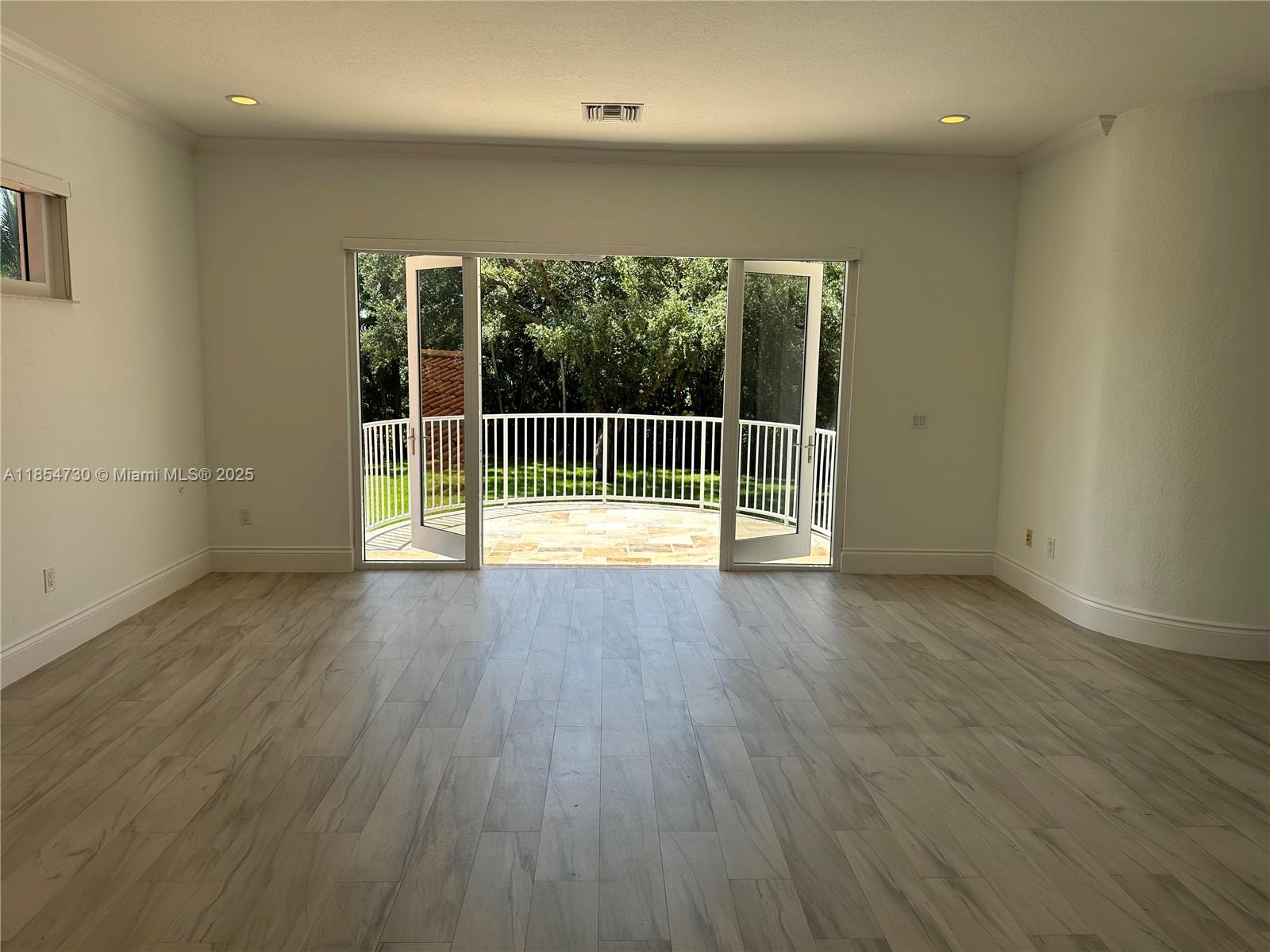 10600 Southwest 69th Avenue Pinecrest, FL 33156 - Photo 15 of 55 an empty room with wooden floor and windows