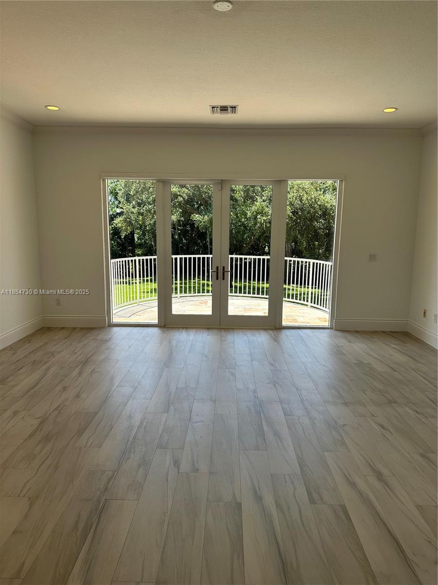 10600 Southwest 69th Avenue Pinecrest, FL 33156 - Photo 17 of 55 an empty room with wooden floor and a wooden floor
