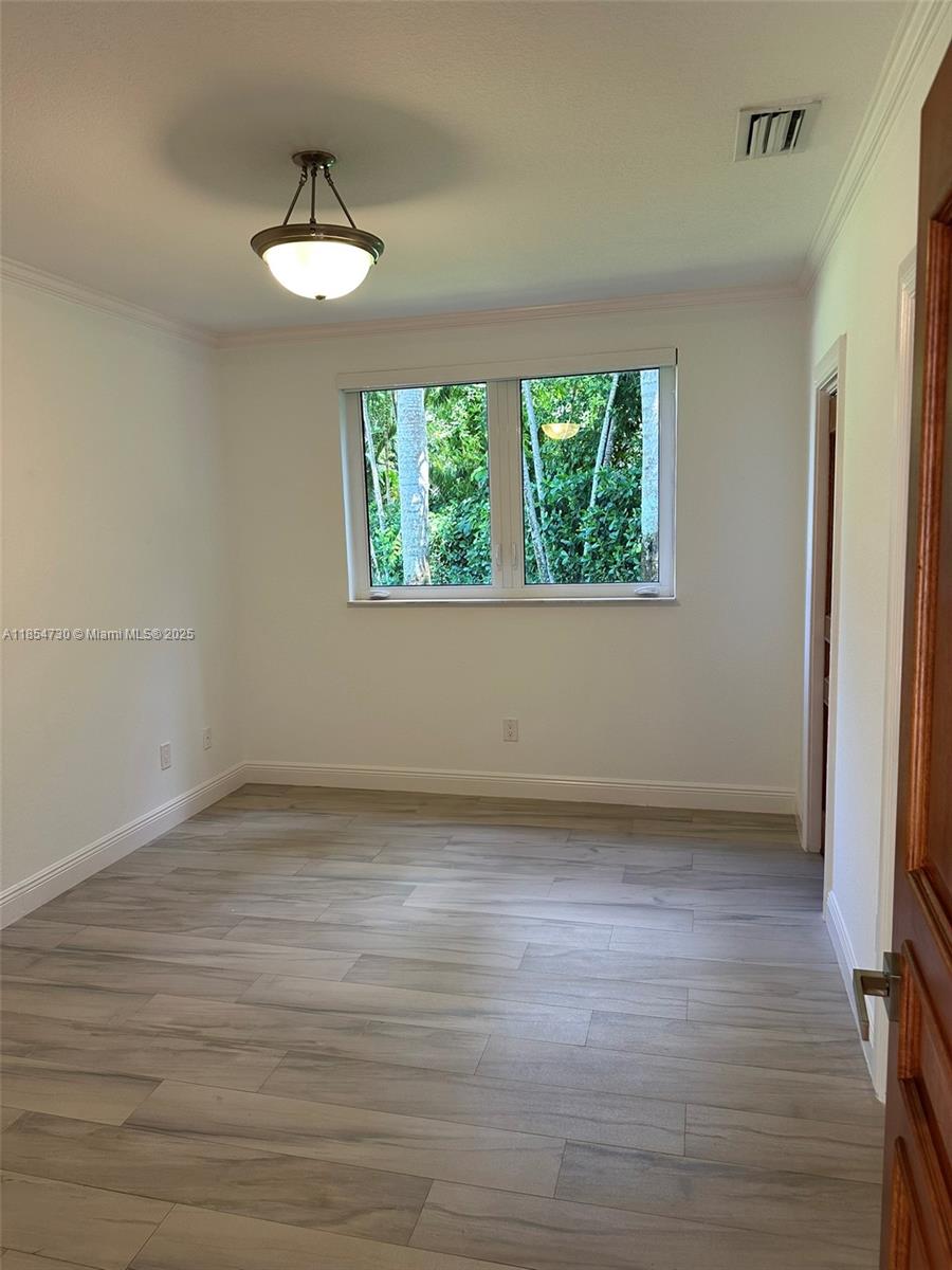 10600 Southwest 69th Avenue Pinecrest, FL 33156 - Photo 33 of 55 an empty room with wooden floor and windows