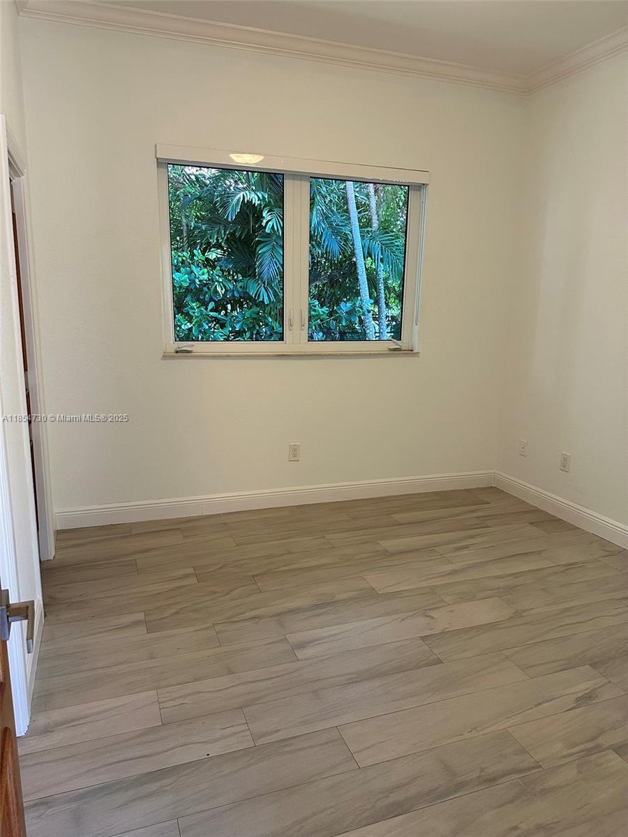 10600 Southwest 69th Avenue Pinecrest, FL 33156 - Photo 34 of 55 an empty room with wooden floor and windows