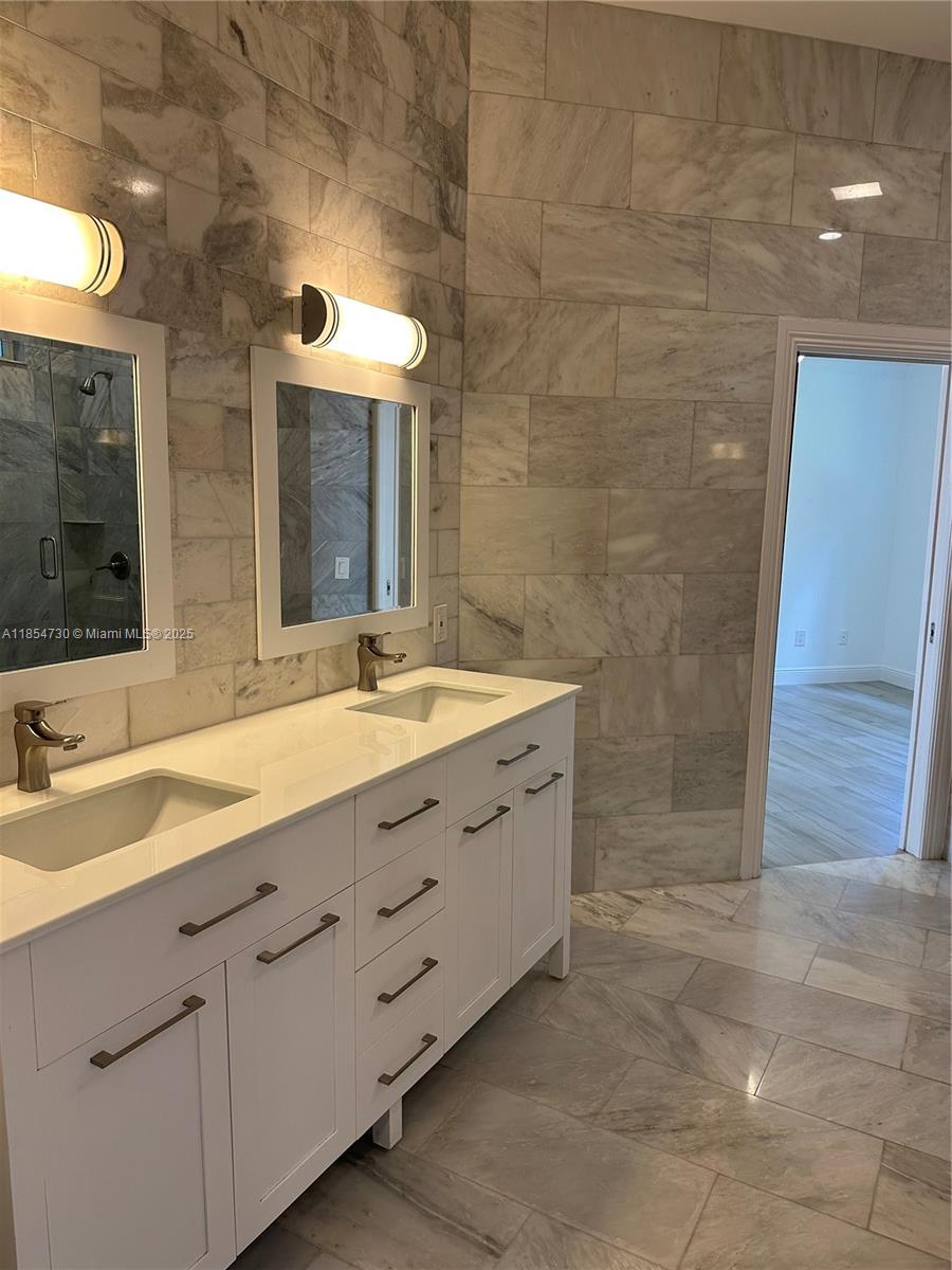 10600 Southwest 69th Avenue Pinecrest, FL 33156 - Photo 35 of 55 a bathroom with a double vanity sink a mirror and a shower