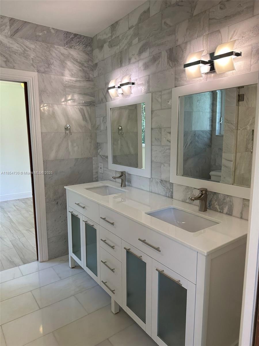 10600 Southwest 69th Avenue Pinecrest, FL 33156 - Photo 38 of 55 a bathroom with a double vanity sink mirror and shower