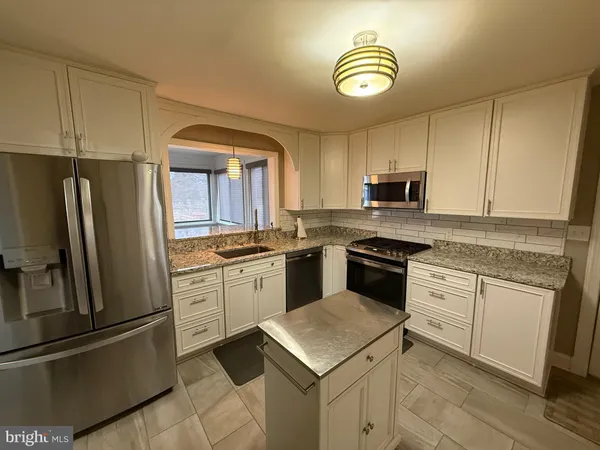 a kitchen with granite countertop cabinets stainless steel appliances and a sink