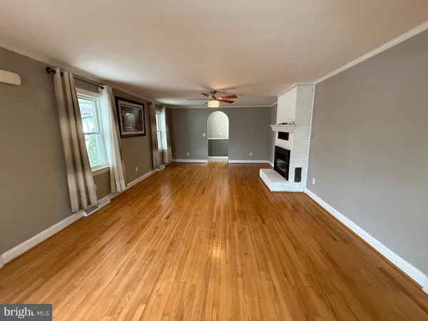 a view of a livingroom with wooden floor and staircase
