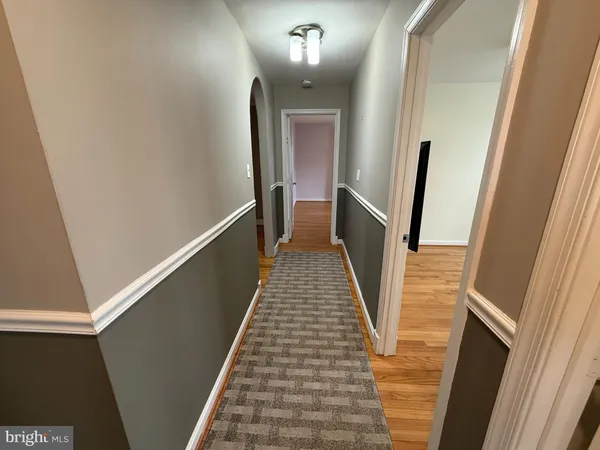 a view of a hallway with wooden floor and stairs