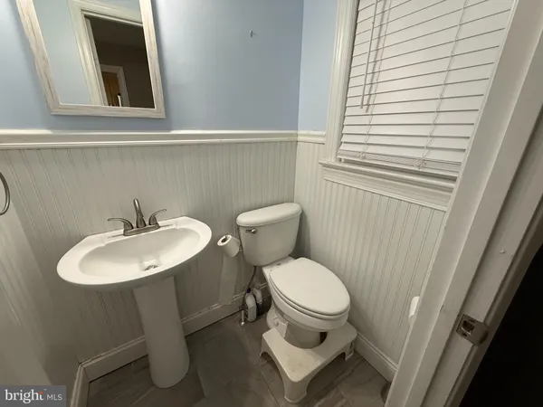 a bathroom with a sink toilet and a mirror