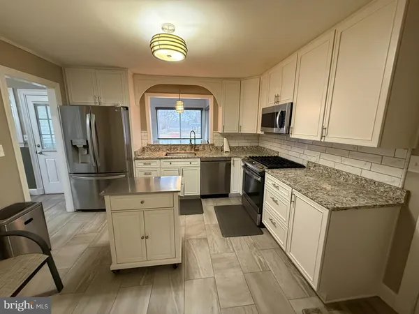 a kitchen with stainless steel appliances granite countertop a stove refrigerator and microwave