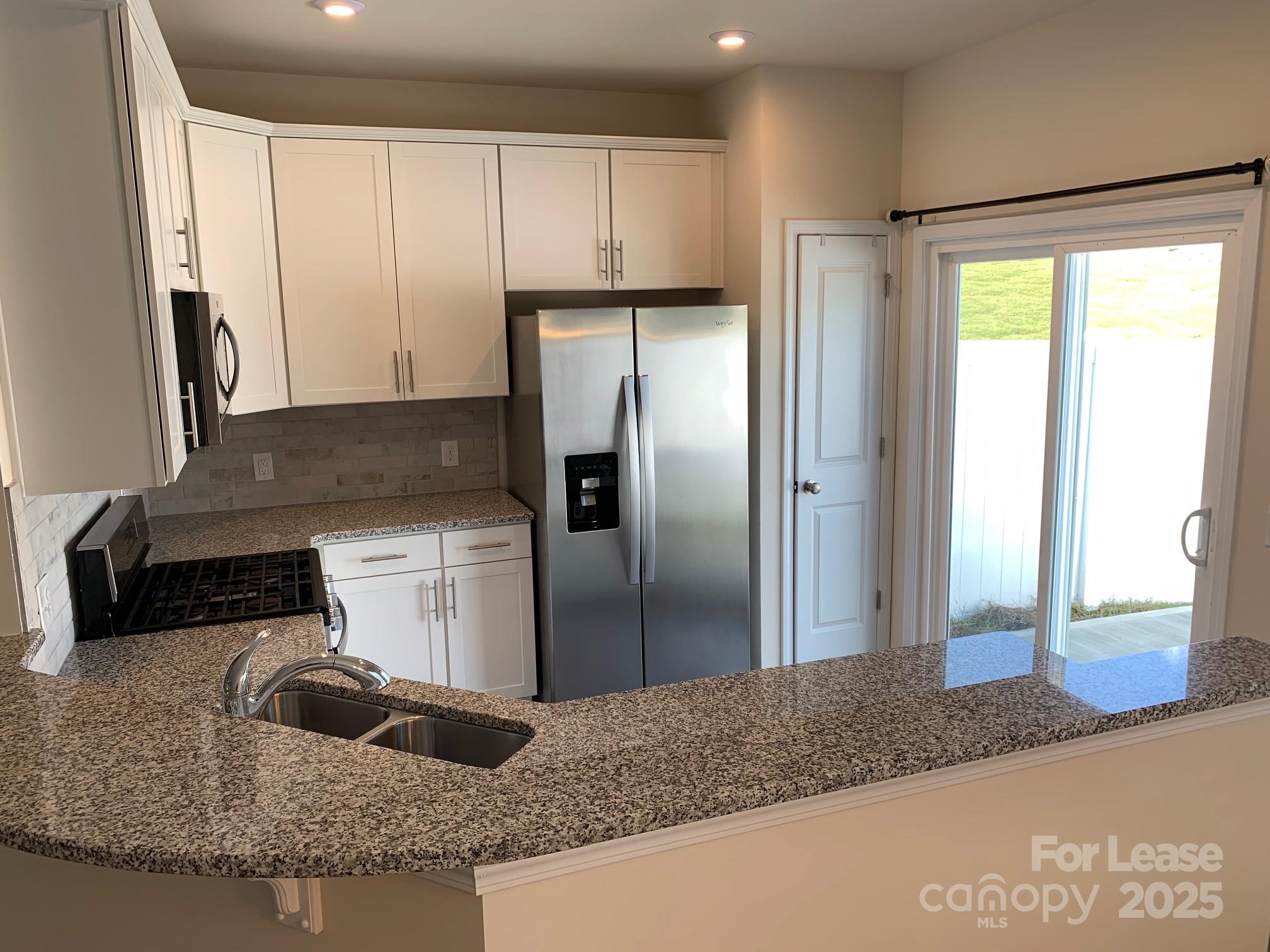 905 Wicawa Road Fort Mill, SC 29708 - Photo 12 of 29 a kitchen with granite countertop a refrigerator and a sink