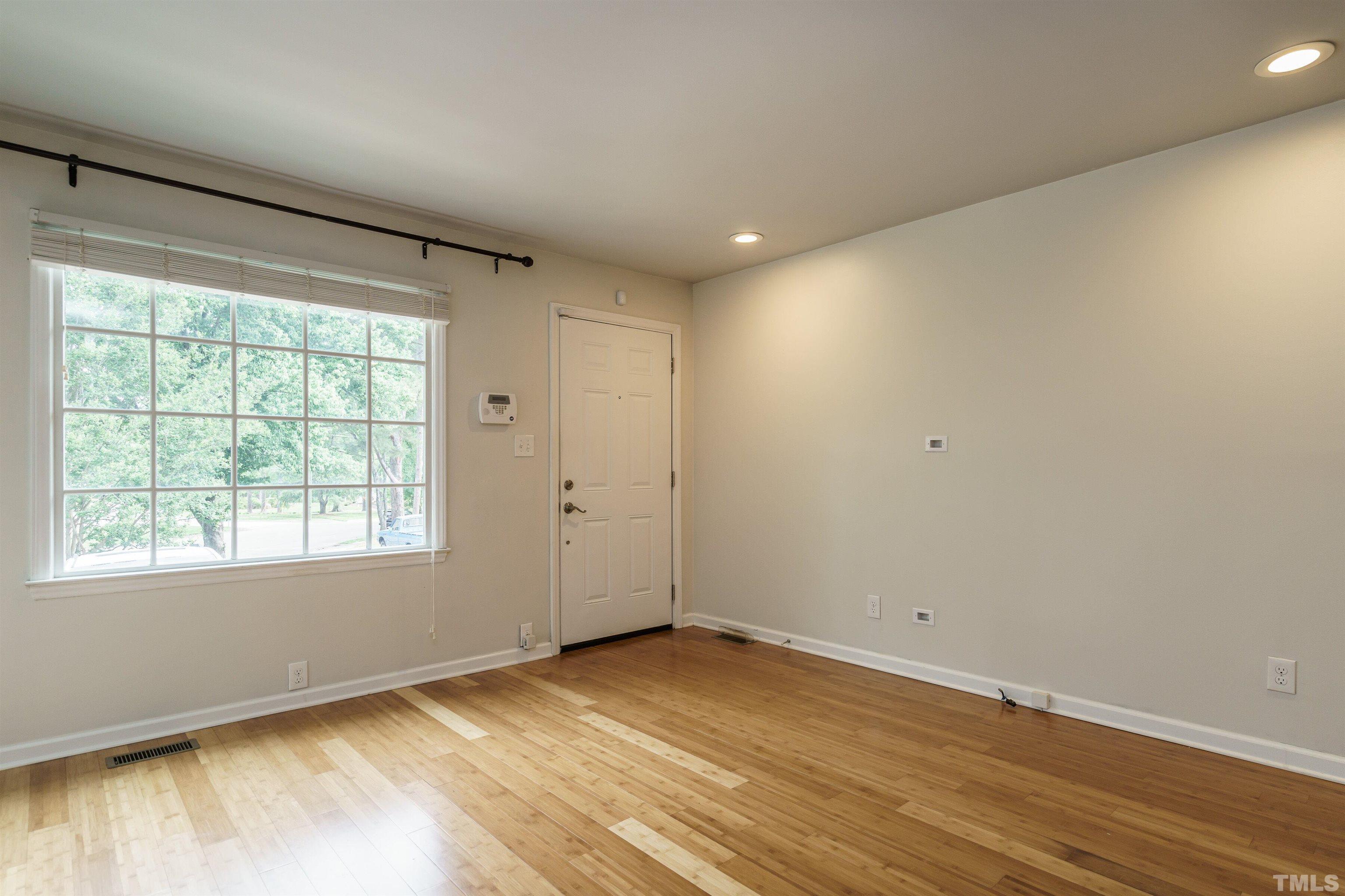 2502 Noble Road Raleigh, NC 27608 - Photo 3 of 19 an empty room with wooden floor and windows