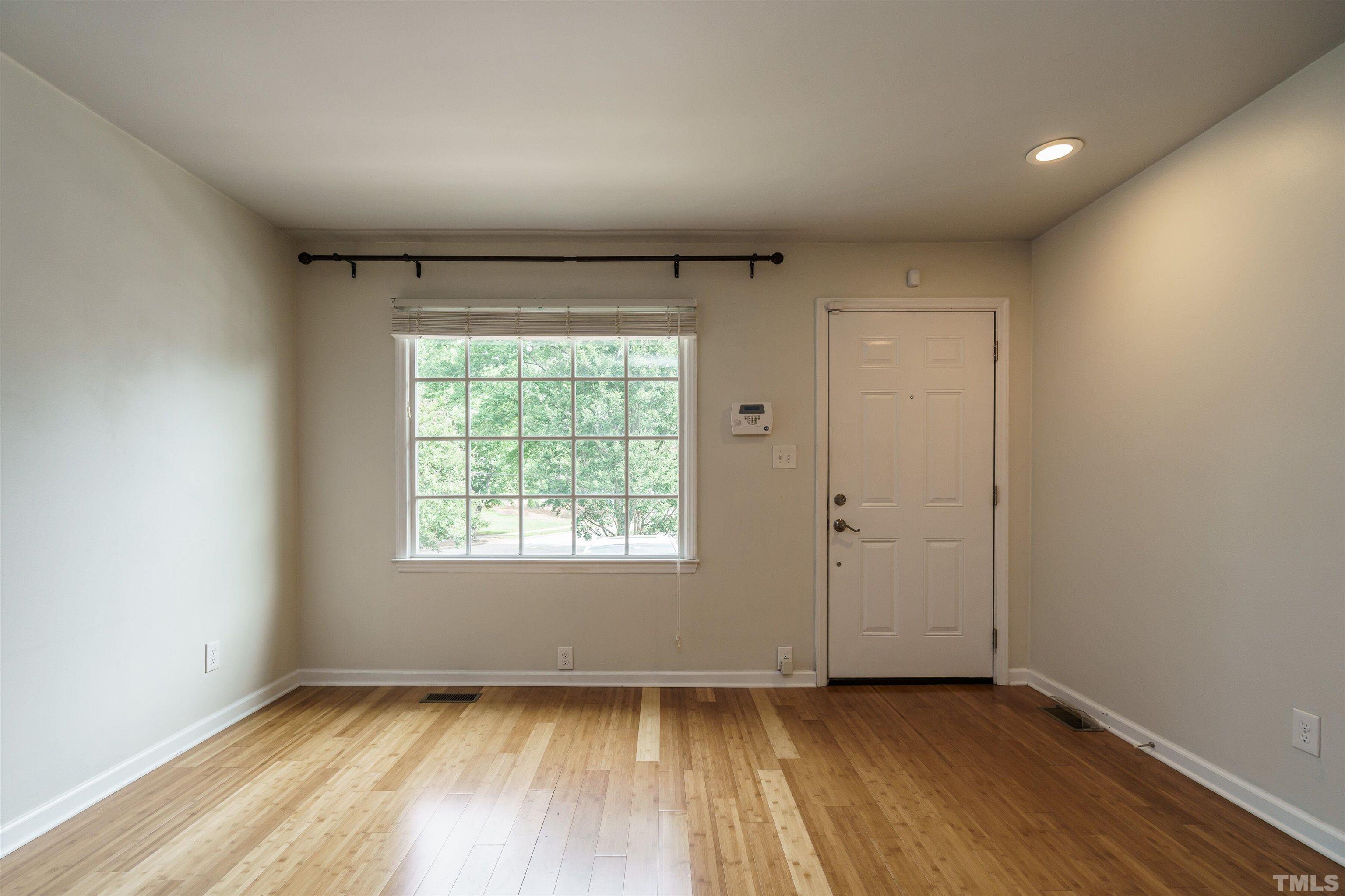 2502 Noble Road Raleigh, NC 27608 - Photo 7 of 19 an empty room with wooden floor and windows