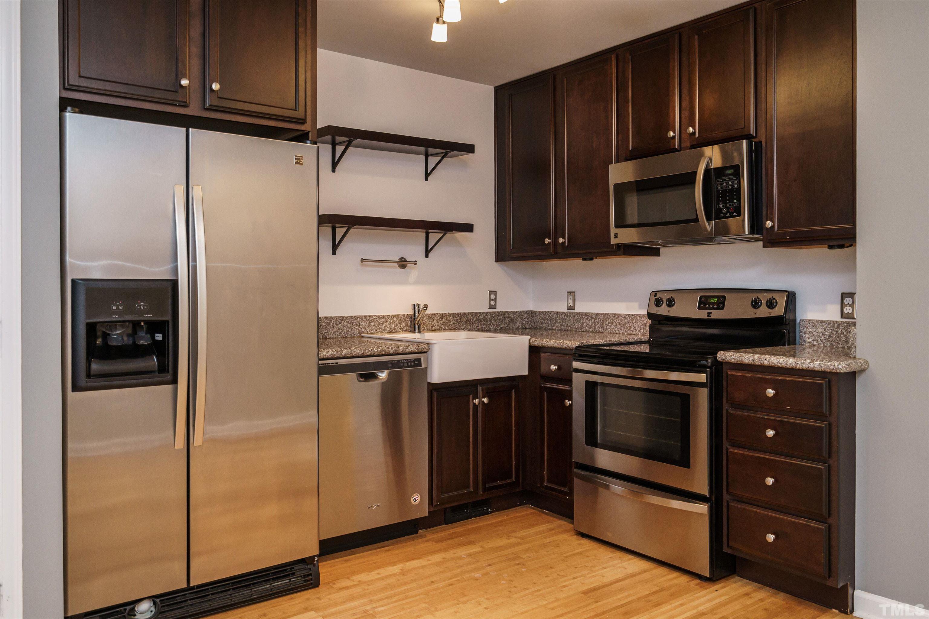 2502 Noble Road Raleigh, NC 27608 - Photo 10 of 19 a kitchen with stainless steel appliances granite countertop wood cabinets a refrigerator and a sink
