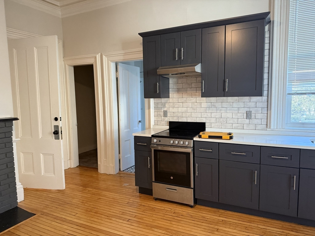 73 Elm Road, Unit 4 Newton, MA 02460 - Photo 6 of 12 a kitchen with stainless steel appliances granite countertop a stove and a refrigerator