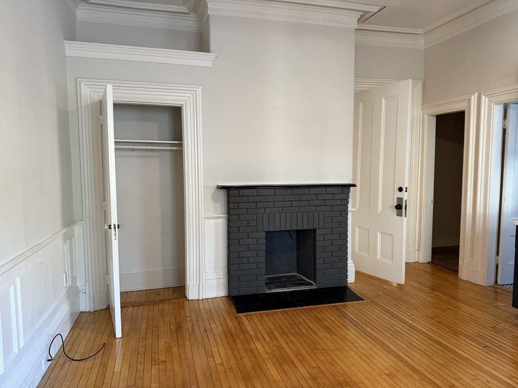 73 Elm Road, Unit 4 Newton, MA 02460 - Photo 7 of 12 a view of an empty room with wooden floor and a fireplace