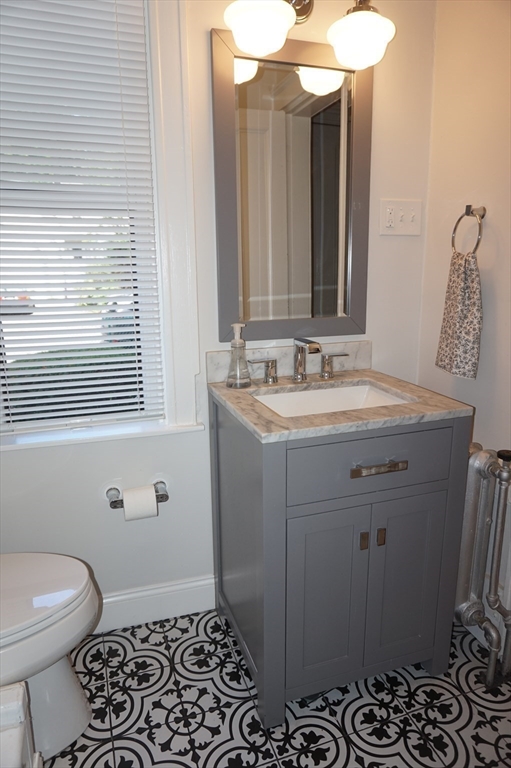 73 Elm Road, Unit 4 Newton, MA 02460 - Photo 9 of 12 a bathroom with a sink a toilet and a mirror