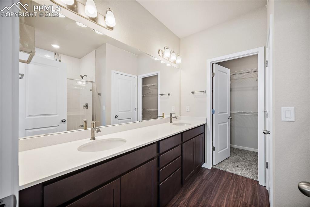 9653 Pinpoint Drive Fountain, CO 80817 - Photo 19 of 34 a bathroom with a double vanity sink a mirror and a shower