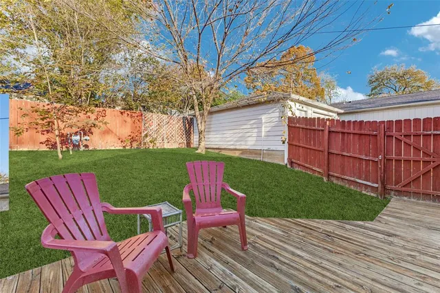 a view of a deck with table and chairs with wooden floor and fence