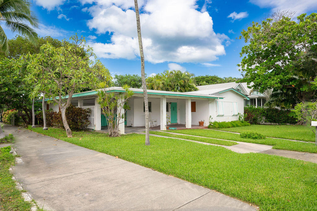 a front view of a house with a yard and trees