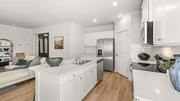 a kitchen with a sink dishwasher a stove and a refrigerator with wooden floor