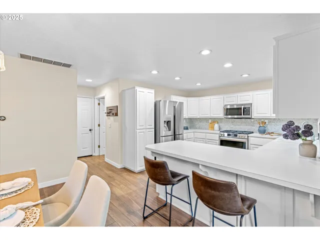 a kitchen with stainless steel appliances a refrigerator and a stove top oven