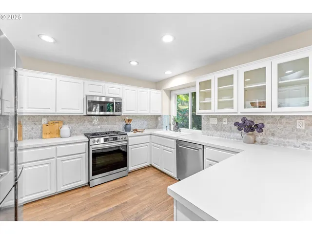 a kitchen with stainless steel appliances granite countertop a stove sink and cabinets