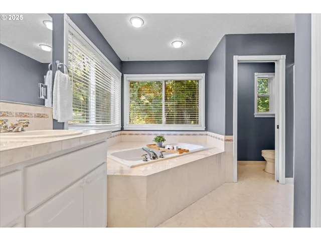 a bathroom with a sink a bathtub and next to a window