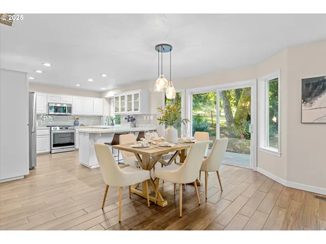 a dining room with furniture a chandelier and wooden floor