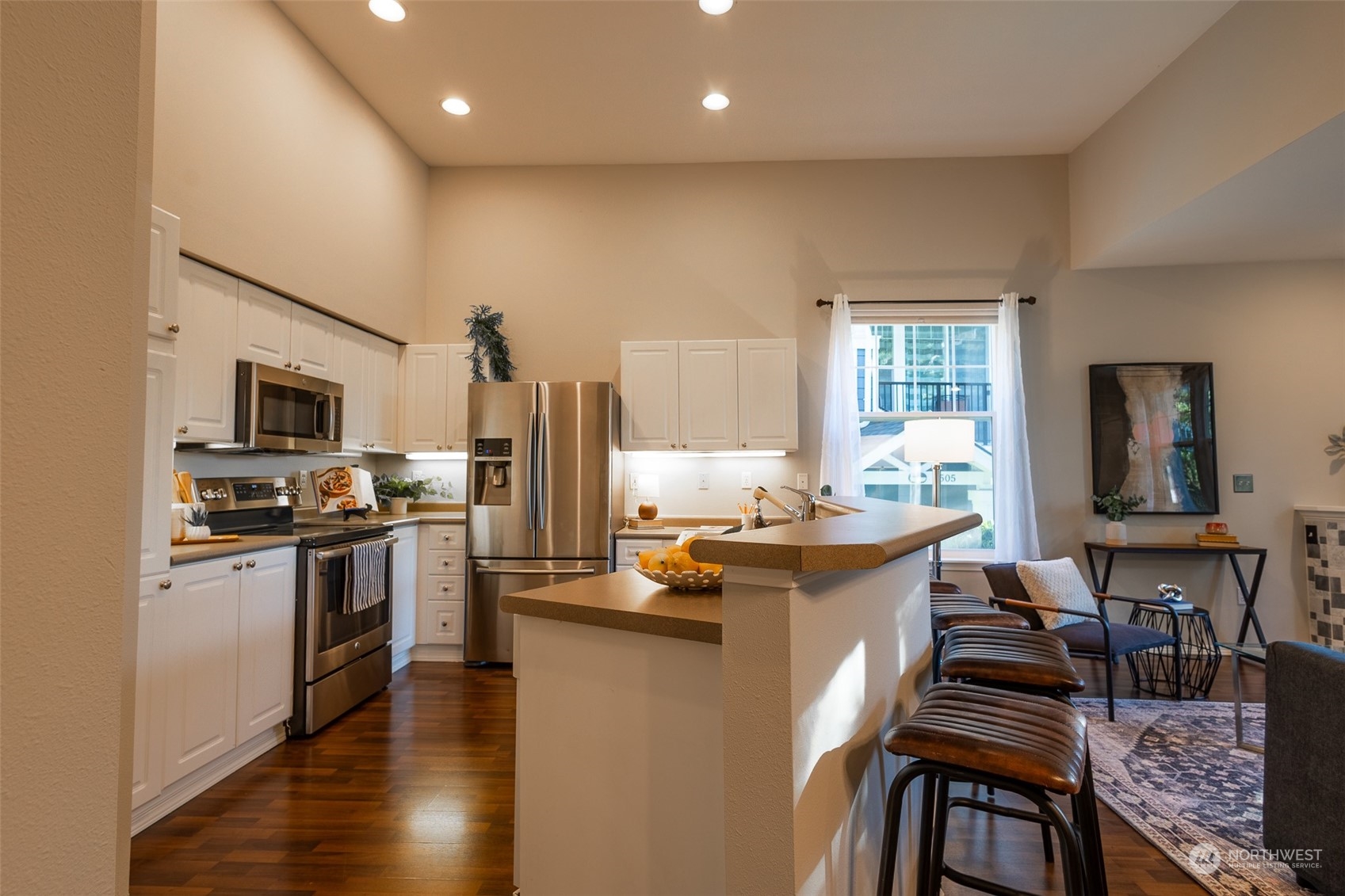 16125 Juanita Woodinville Way Northeast, Unit 2201 Bothell, WA 98011 - Photo 9 of 35 a kitchen with stainless steel appliances a stove a sink dishwasher a refrigerator oven and white cabinets with wooden floor