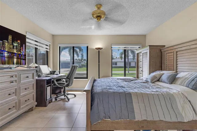 a bed sitting in a spacious bedroom next to a window