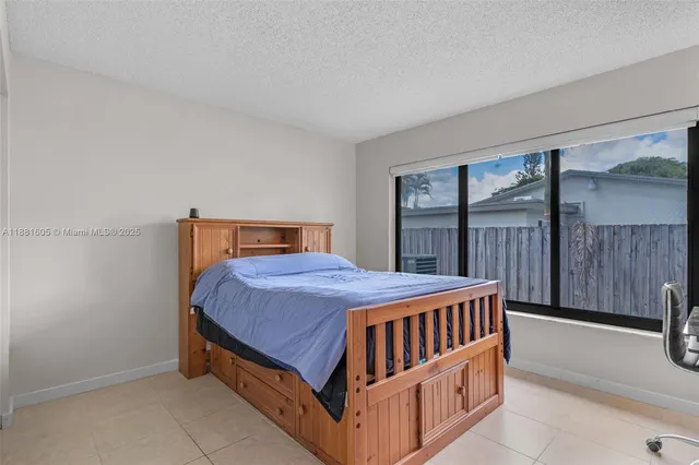 a bedroom with bed and a large window
