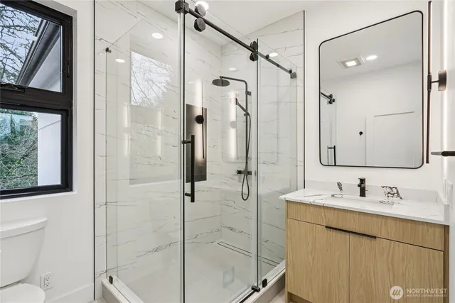 a bathroom with a shower sink vanity and mirror
