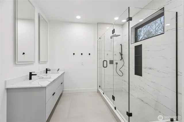 a bathroom with a double vanity sink a mirror and shower