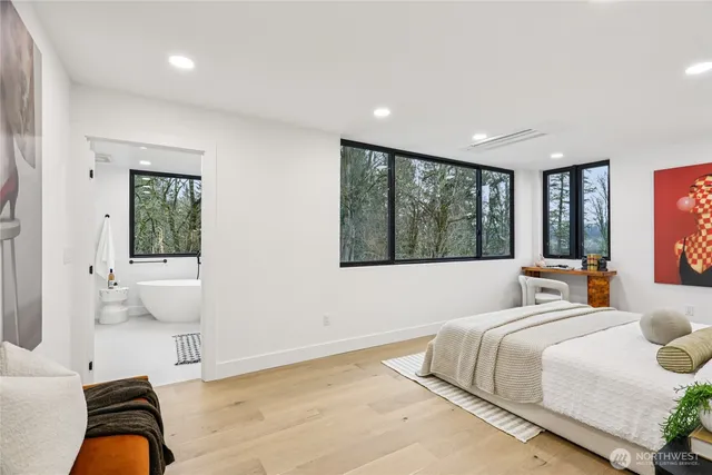 a bedroom with a large bed and windows