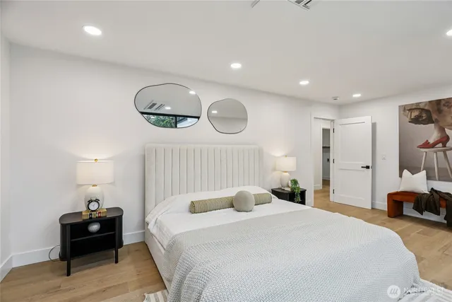 a bedroom with a bed and a lamp with wooden floor