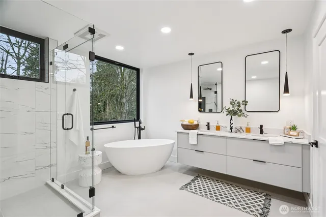 a bathroom with a double vanity sink a mirror and a bathtub