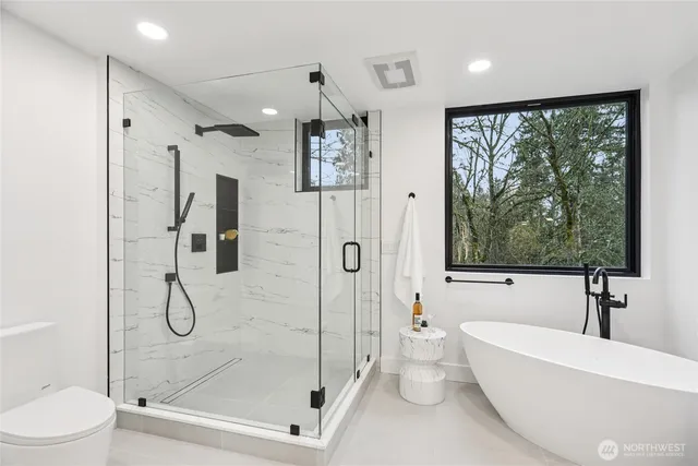 a bathroom with a bathtub shower and toilet