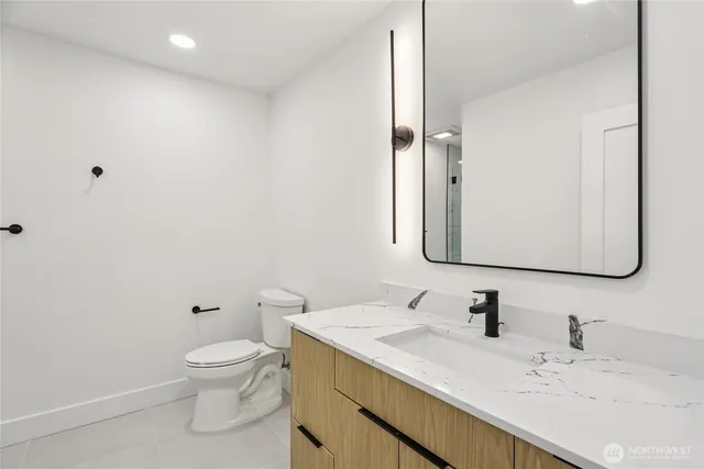a bathroom with a granite countertop sink mirror and toilet