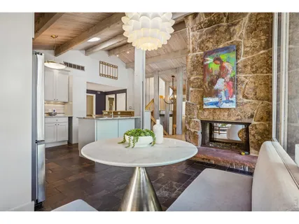 a living room with stainless steel appliances kitchen island a table and chairs