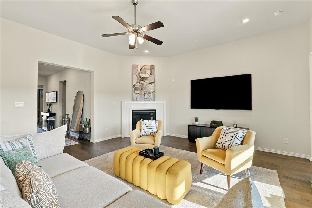 137 Chisos Court Rhome, TX 76078 - Photo 8 of 40 Spacious living area featuring wood-finish flooring, a ceiling fan, recessed lighting, and a built-in fireplace with a mantel