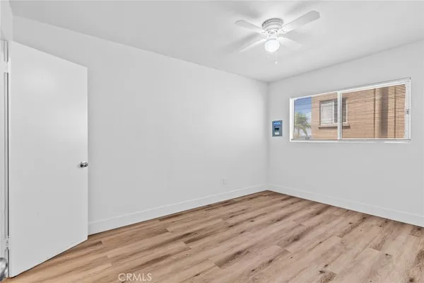 a view of a room with wooden floor and a ceiling fan
