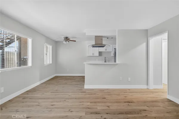 a view of empty room with wooden floor and window