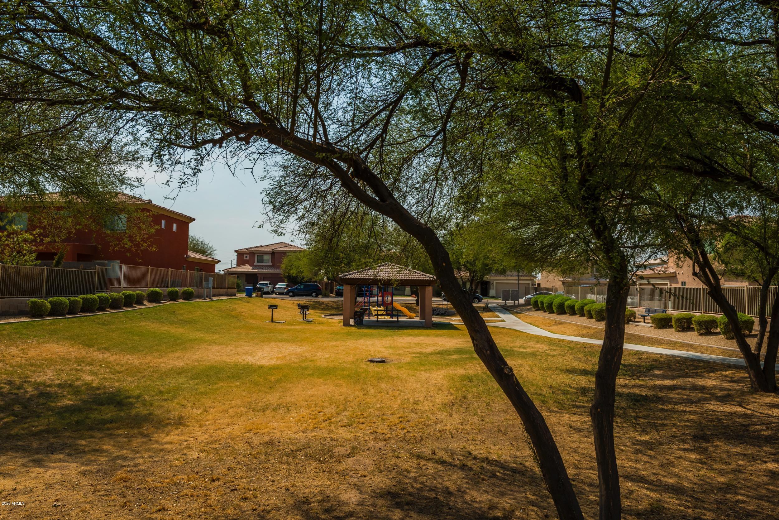 1407 East Fremont Road Phoenix, AZ 85042 - Photo 20 of 27 a view of swimming pool with lawn chairs and large trees