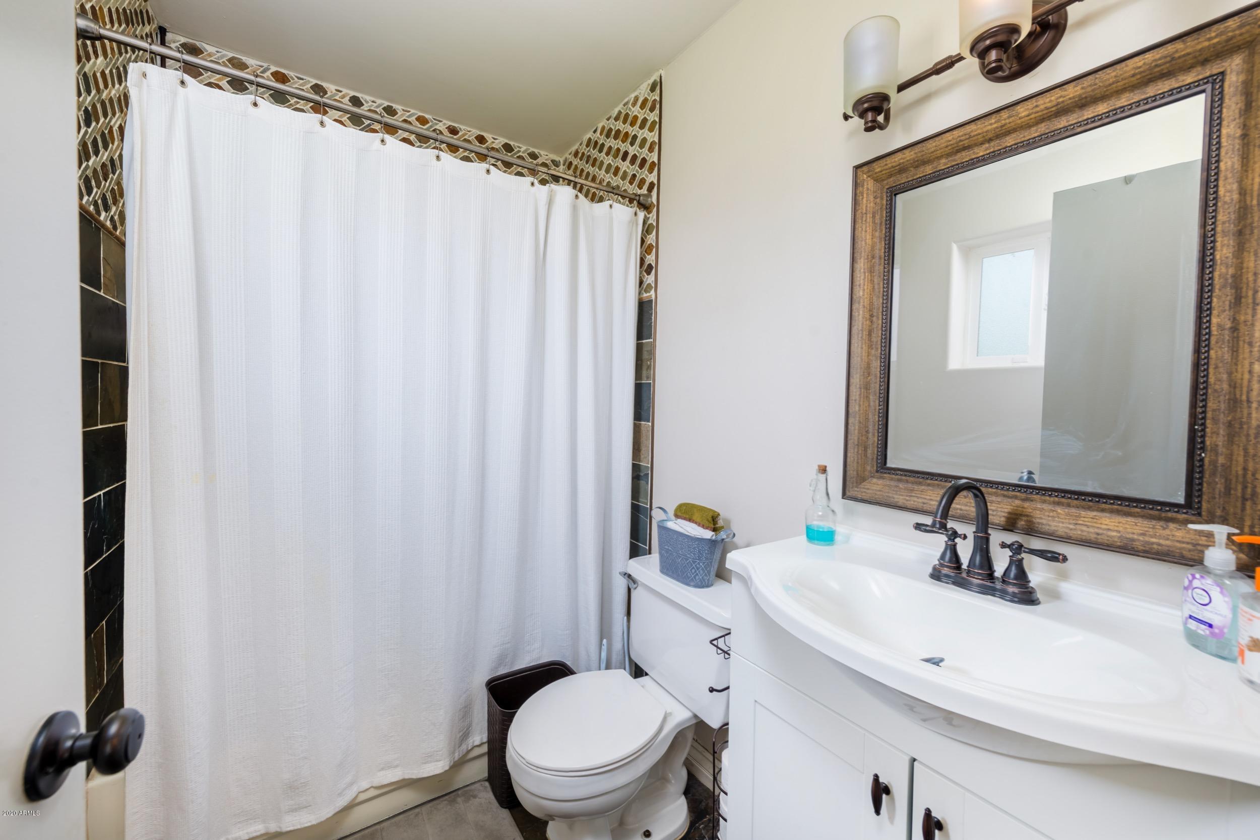 1407 East Fremont Road Phoenix, AZ 85042 - Photo 24 of 27 a bathroom with a sink a toilet and shower curtain