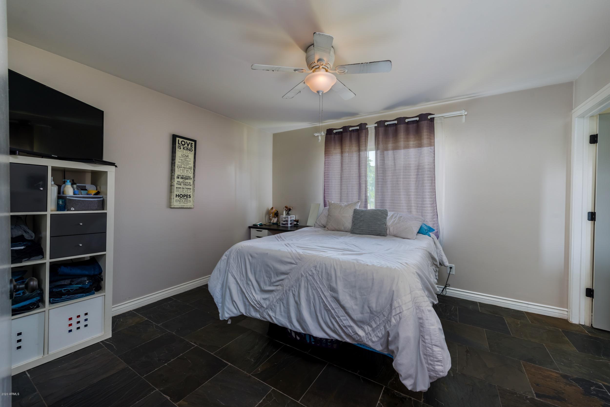 1407 East Fremont Road Phoenix, AZ 85042 - Photo 10 of 27 a bedroom with a bed and a flat tv screen