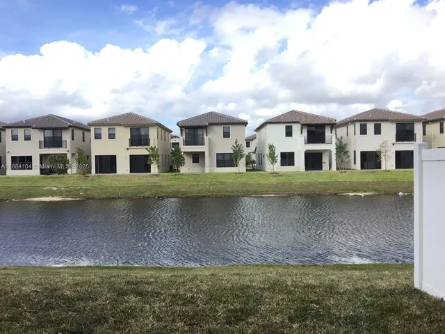 a view of a big house with a big yard and large trees