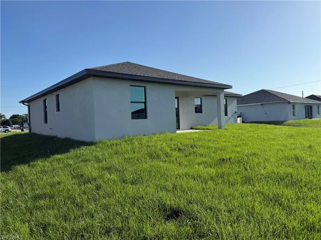 a house with green field in front of it
