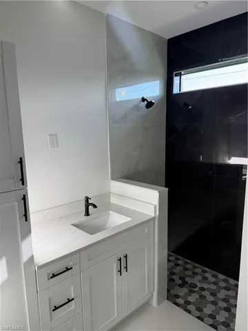 a bathroom with a sink shower and a mirror