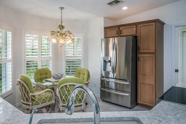 a dining room with furniture a chandelier and wooden floor