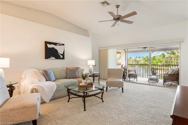 a living room with furniture and a large window with garden view